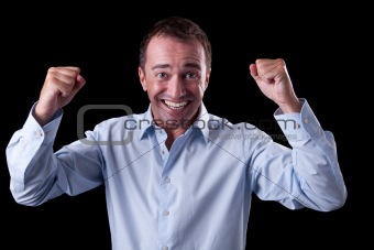 Portrait of a very happy  businessman with his arms raised, on black background. Studio shot
