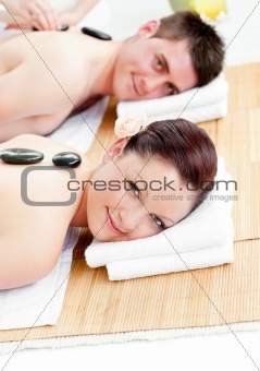 Cute young couple receiving a back massage with hot stones