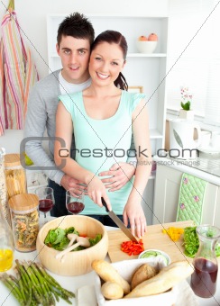 Enamored young couple cutting vegetables in the kitchen