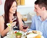 Laughing caucasian couple having dinner at home