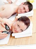 Attractive young couple receiving a back massage with hot stones
