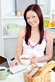 Radiant woman using her laptop during breakfast at home