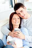 Positive young couple drinking coffee on a sofa
