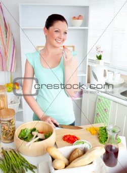 Glowing young woman tasting her salad at home