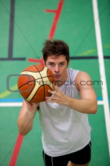 Portrait of a muscular young man playing basket-ball