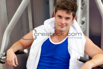 Handsome muscular man using a bench press