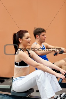 Athletic people using a rower