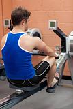 Athletic caucasian man using a rower