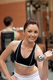 Portrait of an attractive woman working out with dumbbells