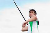 Handsome male athlete throwing a javelin
