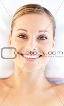 Portrait of a smiling young woman lying on a massage table