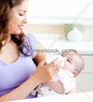 Radiant mother feeding her adorable son in the kitchen