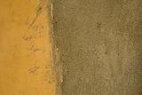 Grunge yellow painted wall with cement area 