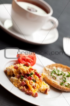scrambled eggs and ham cubes on a white plate