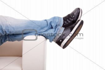 Detail, of some legs stretched on the couch, isolated on white, studio shot