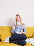 woman sitting on sofa and having coffee