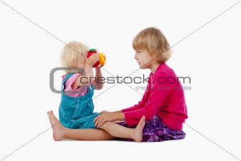 sisters taking pictures of each other with toy camera - isolated on white
