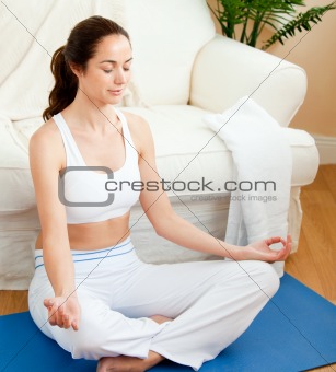 Young woman sitting on the floor doing yoga
