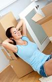 Relaxing woman sitting on the floor after unpacking boxes