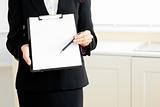 Close-up of a businesswoman holding a clipboard and a pen