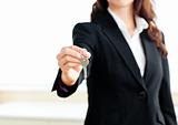 Close-up of a confident businesswoman holding a key