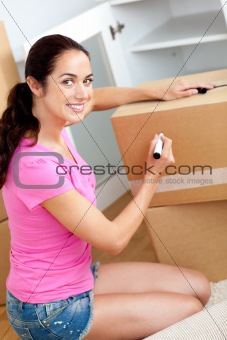 Delighted woman writing on a box