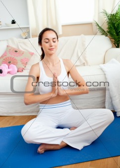 Young woman meditating in her living-room