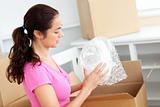 Young caucasian woman unpacking boxes with glasses