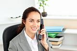 Attractive businesswoman talking on phone sitting in her office