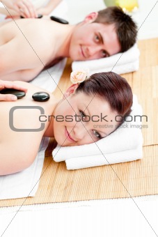 Bright caucasian couple enjoying a back massage in a spa center