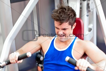 Muscular young man using a bench press