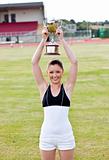 Cheerful female athlete holding a trophee