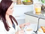 Businesswoman drinking coffee sitting in the kitchen at home