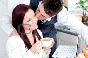 Handsome businessman kissing his bright girlfriend while having 