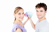 Smiling young couple choosing color for a room