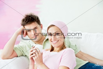 Relaxing couple lying on a sofa after painting a room