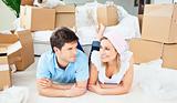 Young couple lying on the floor after unpacking boxes