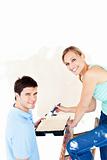 Attractive caucasian couple painting a room