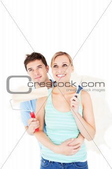 Affectionate caucasian couple painting a room
