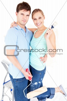 Loving caucasian couple painting a room