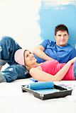 Bright young couple relaxing after painting a room