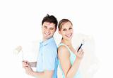 Bright young couple painting a room