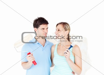 Lovely young couple painting a room