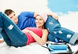 Happy young couple relaxing after painting a room