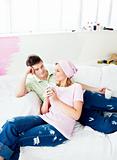 Enamored caucasian couple lying on a sofa after painting a room