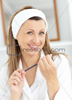 Cheerful woman filling her nails in the bathroom