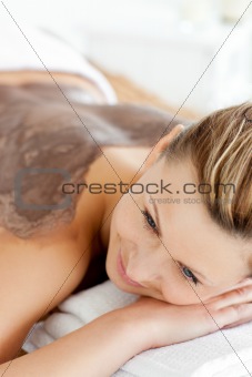 young woman enjoying a beauty treatment with mud