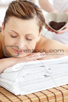 Smiling caucasian woman lying on a massage table in a spa center