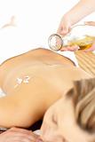 Glad young woman enjoying a back massage with oil