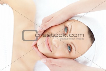 Charming young woman enjoying a facial massage 